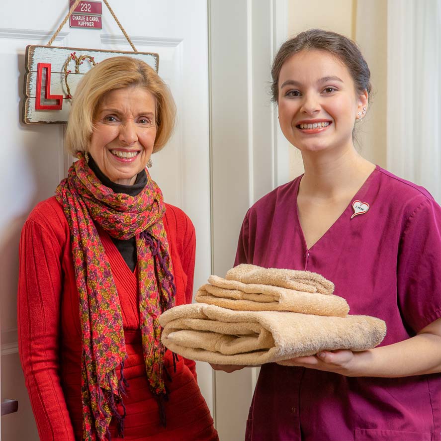 A team member delivering fresh linens to a resident at Kennedy Meadows